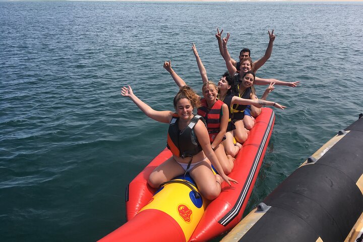 Grupo de amigas disfruta paseo en banana boat en despedida de soltera en la playa
