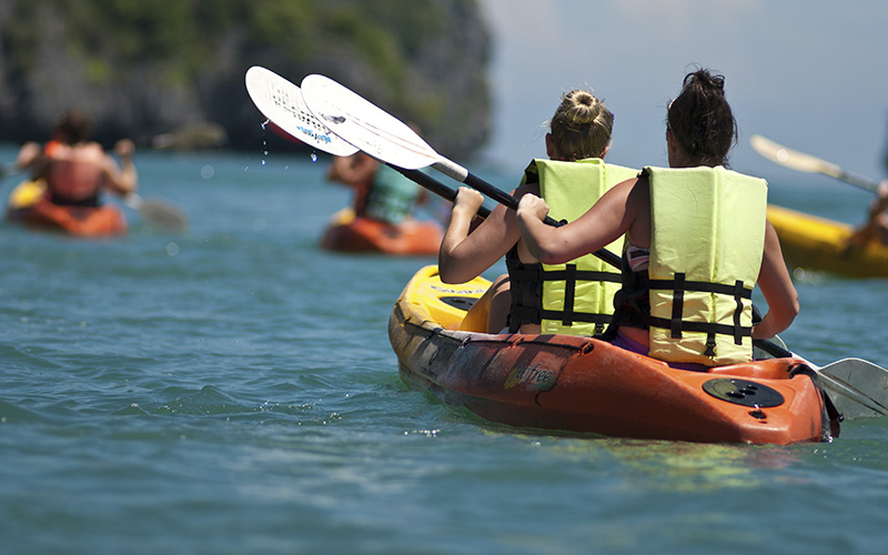 Dos amigass hacen kayak en despedida de soltera en la playa